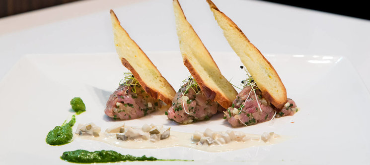 Tartare de mignon de veaux au Gruyère AOP, tuile de pain de seigle AOP, pesto de roquette et crème double à la liqueur de poire à botzi